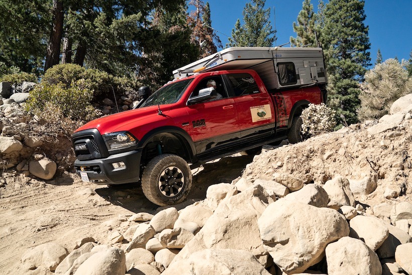 red dodge ram truck with slide-in pop camper in the bed
